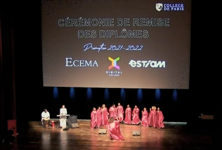 Chœur en robes rouges chantant sur scène lors de la cérémonie de remise des diplômes du Collège de Paris, promotion 2021-2022.