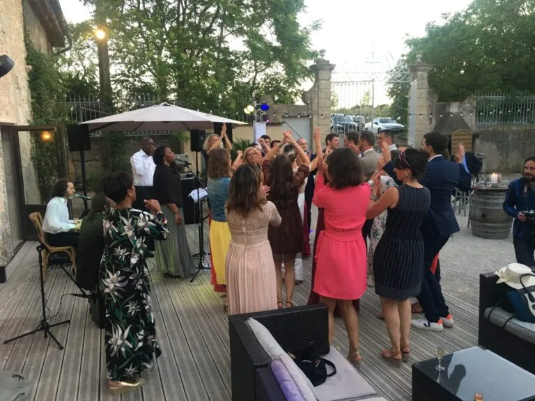 Jazz Pearl's, une animation musicale en plein air lors d’un mariage. Un groupe de chanteurs et musiciens accompagne la soirée tandis que les invités, vêtus de tenues élégantes, dansent et applaudissent sous un ciel étoilé.