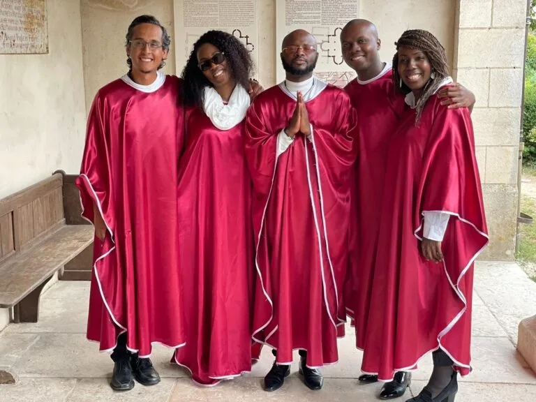 Amany, chorale gospel en tenue rouge, souriante et prête à chanter pour un événement ou une cérémonie.