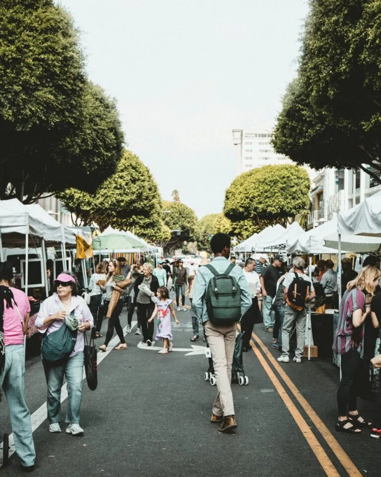 Marché en plein air animé avec des stands et des visiteurs profitant de l’ambiance conviviale.