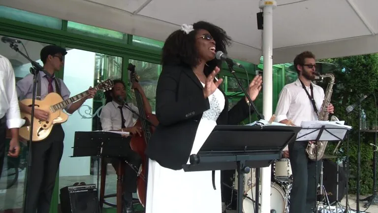 Jazz Pearl's, groupe de musique jazz en live avec chanteuse, guitare, contrebasse, saxophone et batterie lors d’un événement en plein air.