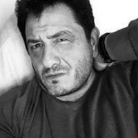 Portrait en noir et blanc d’un homme avec un regard intense, la main posée sur la nuque.