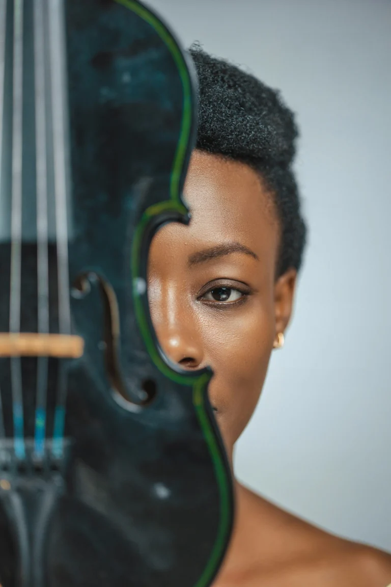 Portrait d’une musicienne tenant un violon devant son visage